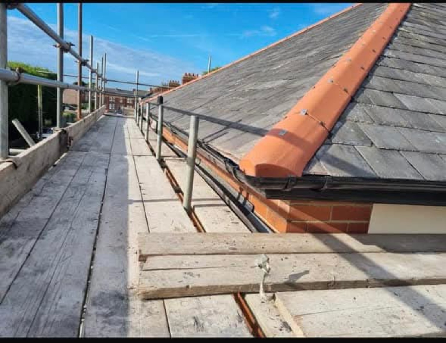Scaffolding beside pitched slate roof